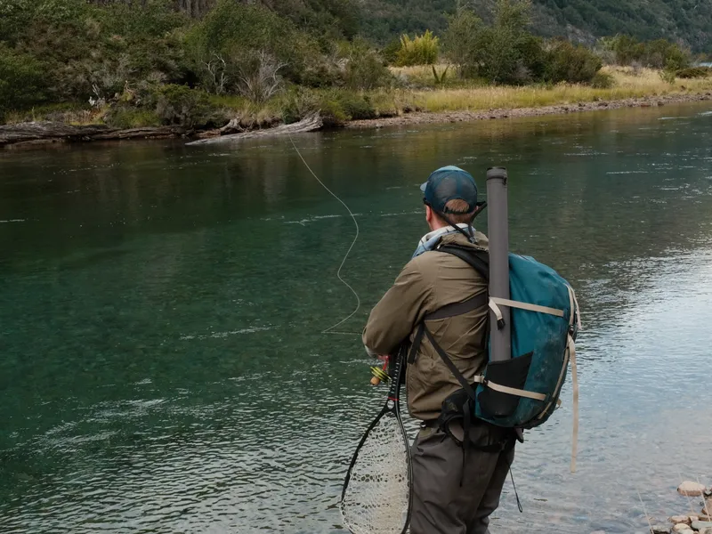 Angler watching emerald river from bank