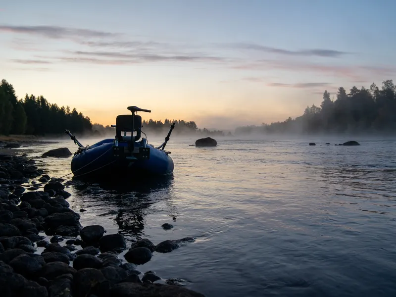 The raft on the bank at dawn, mist on the river